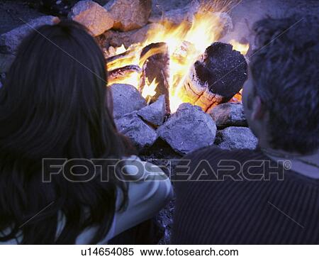 Couple sit by the fire View Large Photo Image Stock Photography - Couple sit by the fire. Fotosearch