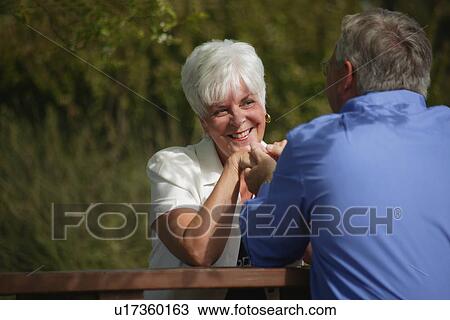 Couple sits outside together View Large Photo Image Stock Image - Couple sits outside together. Fotosearch