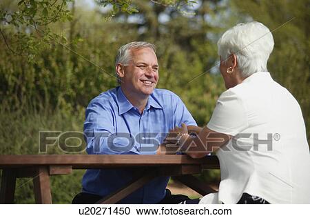 Couple sits outside together View Large Photo Image Stock Image - Couple sits outside together. Fotosearch