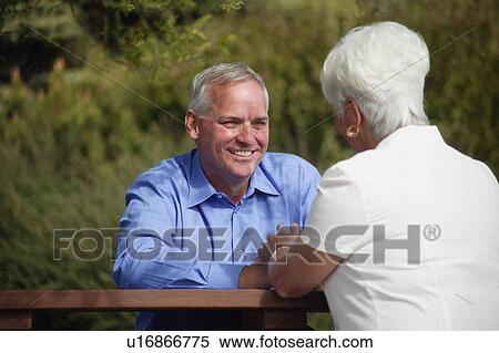 Couple sits outside together View Large Photo Image Stock Photography - Couple sits outside together. Fotosearch