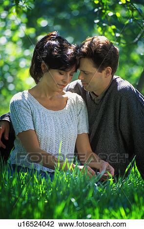 Couple sitting on the grass View Large Photo Image Stock Image - Couple sitting on the grass. Fotosearch