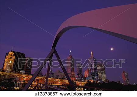 Curved span of bridge with city skyline in background View Large Photo Image Stock Photo - Curved span of bridge with city skyline in background. Fotosearch