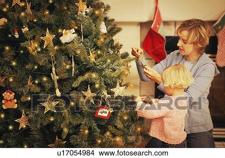 Picture - Decorating a Christmas tree. Fotosearch