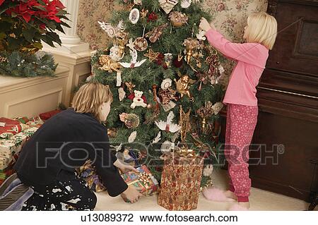 Stock Image - Decorating the tree for Christmas. Fotosearch