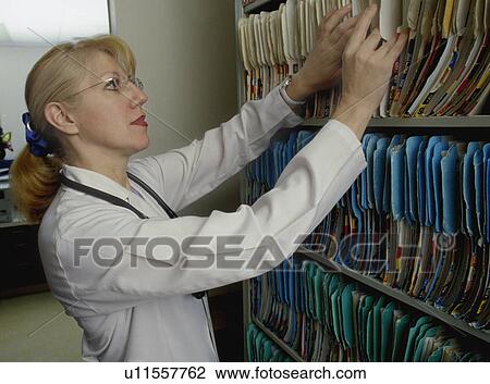Doctor or nurse looking for patient's records View Large Photo Image Stock Image - Doctor or nurse looking for patient's records. Fotosearch