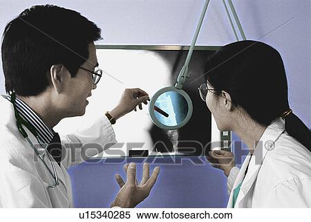 Doctors examining an x-ray View Large Photo Image Stock Photography - Doctors examining an x-ray. Fotosearch