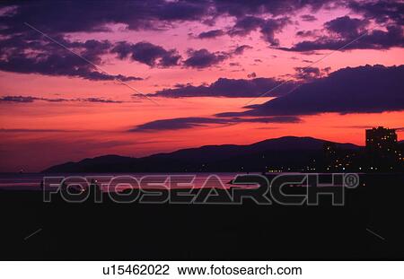 Stock Image - Dramatic sunset over a town. Fotosearch
