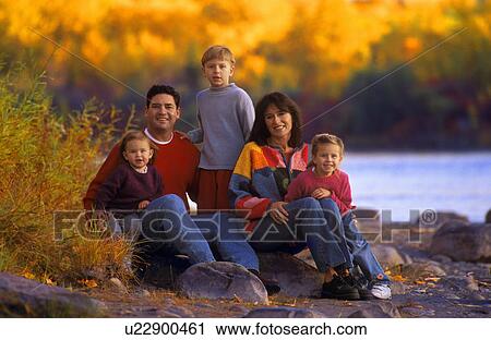 Family sitting on rock near river View Large Photo Image Stock Image - Family sitting on rock near river. Fotosearch