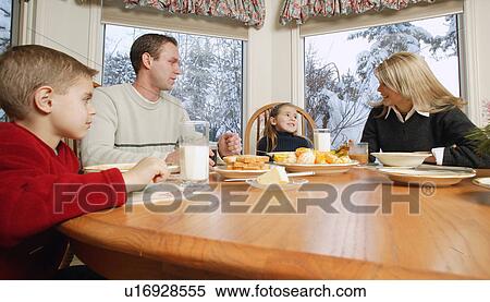 Stock Photography - Family smiles at breakfast table. Fotosearch