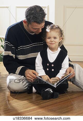 Father reading a book with daughter View Large Photo Image Picture - Father reading a book with daughter. Fotosearch