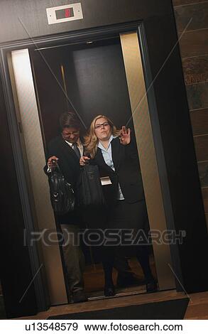 Stock Photo - Fighting to get out of the elevator first. Fotosearch