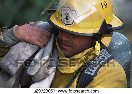 Stock Photo - Fireman carrying hose. Fotosearch