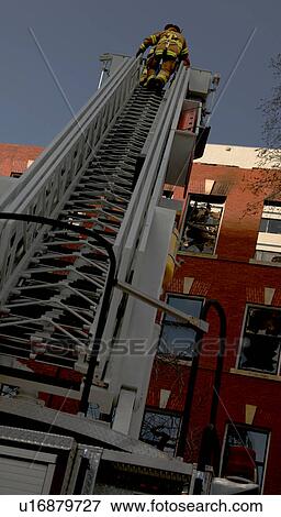 Fireman on ladder near building View Large Photo Image Stock Photo - Fireman on ladder near building. Fotosearch