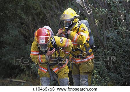 Stock Image - Firemen putting on equipment. Fotosearch