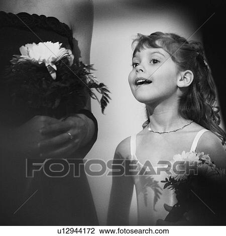 Stock Image - Flower girl peeks at the bride. Fotosearch