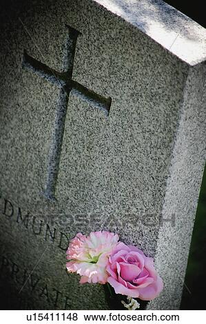 Stock Photo - Flowers on a tombstone. Fotosearch
