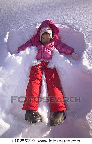 Stock Photo - Girl making a snow angel. Fotosearch