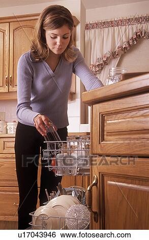 Girl putting dishes into dishwasher View Large Photo Image Stock Photograph - Girl putting dishes into dishwasher. Fotosearch