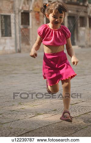 Girl running through street View Large Photo Image Stock Photo - Girl running through street. Fotosearch
