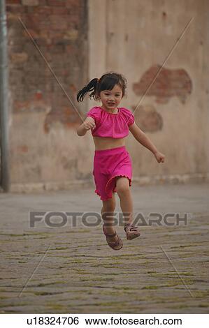 Girl running through street View Large Photo Image Stock Photograph - Girl running through street. Fotosearch