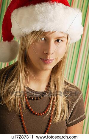Stock Image - Girl wearing Santa hat. Fotosearch