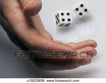 Hand rolling dice on white surface View Large Photo Image Stock Photograph - Hand rolling dice on white surface. Fotosearch