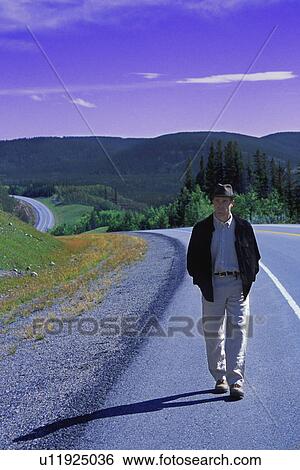 Hiker walking on edge of highway View Large Photo Image Stock Photograph - Hiker walking on edge of highway. Fotosearch
