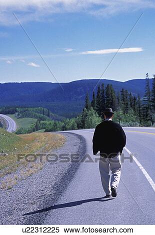 Hiker walking on edge of highway View Large Photo Image Stock Photography - Hiker walking on edge of highway. Fotosearch
