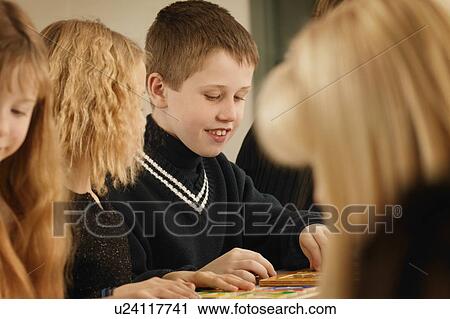 Stock Image - Kids play at a table together. Fotosearch