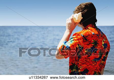 Stock Photo - Listening to the sound of the ocean. Fotosearch