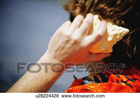 Listening to the sound of the ocean View Large Photo Image Stock Photo - Listening to the sound of the ocean. Fotosearch