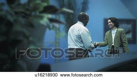 Stock Image - Man and woman shaking hands. Fotosearch