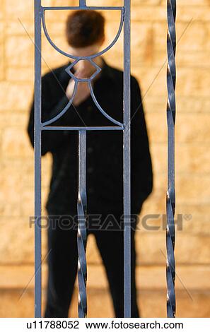 Man behind communion cup on iron fence View Large Photo Image Stock Image - Man behind communion cup on iron fence. Fotosearch
