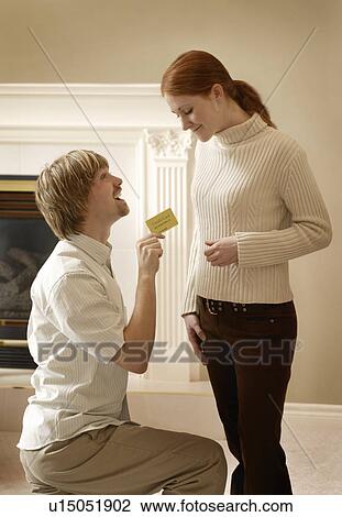 Stock Image - Man proposing to Woman with card. Fotosearch