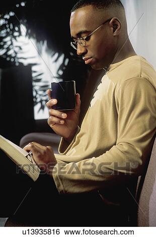 Man reading on couch View Large Photo Image Stock Photograph - Man reading on couch. Fotosearch