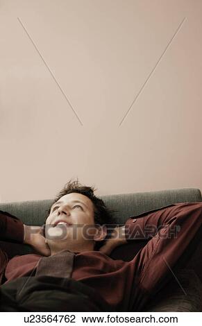Man relaxing on sofa View Large Photo Image Stock Image - Man relaxing on sofa. Fotosearch