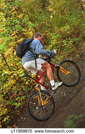 Man riding trail bike in forest View Large Photo Image Stock Image - Man riding trail bike in forest. Fotosearch