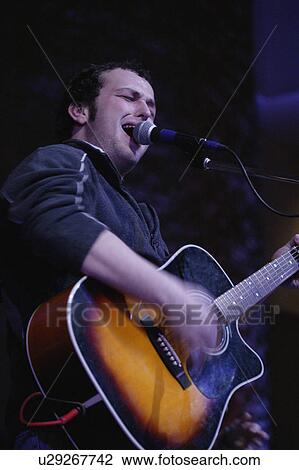 Stock Image - Man singing and playing guitar. Fotosearch