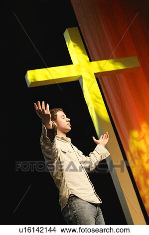 Picture - Man standing beside the cross. Fotosearch