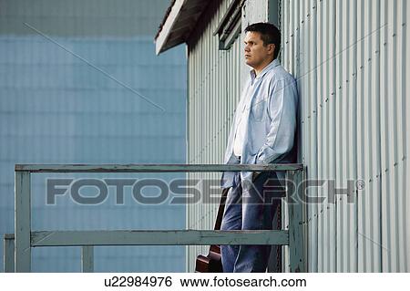 Stock Photograph - Man stands outside. Fotosearch