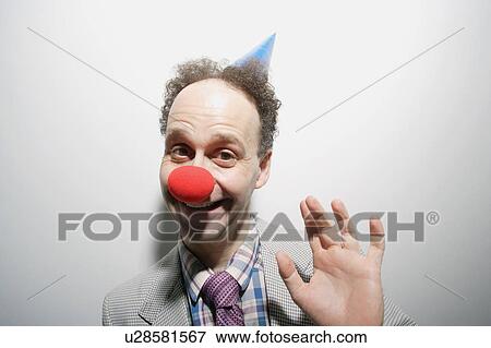 Stock Photo - Man wearing a clown's nose and hat. Fotosearch