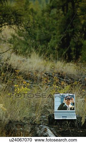 Stock Image - Man with binoculars in field. Fotosearch