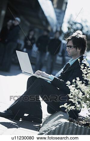 Stock Image - Man working on lap top. Fotosearch