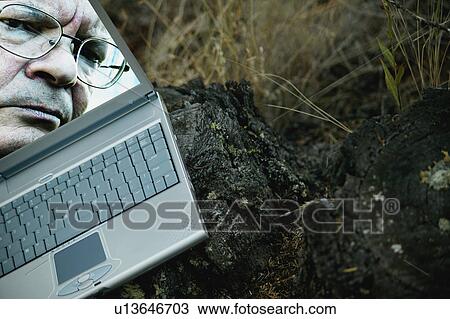 Stock Image - Man's face on laptop computer. Fotosearch