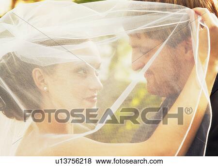 Stock Photo - Married couple behind veil. Fotosearch