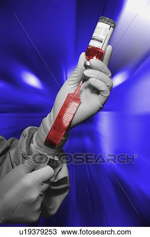 Stock Image - Medical personnel drawing drugs for an injection. Fotosearch