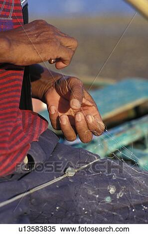 Mending a fishing net View Large Photo Image Stock Photography - Mending a fishing net. Fotosearch
