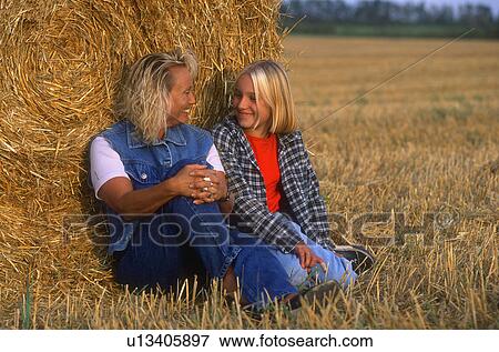 Mom and daughter in hayfield View Large Photo Image Stock Photo - Mom and daughter in hayfield. Fotosearch