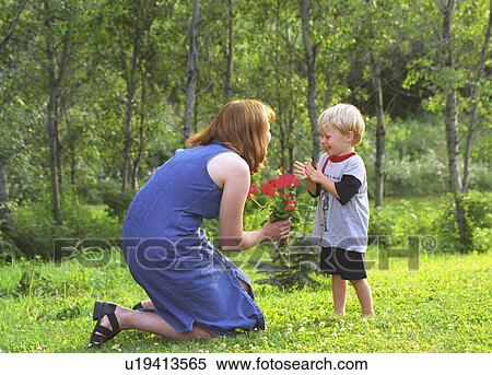 Stock Photography - Mother and son with flowers in park. Fotosearch