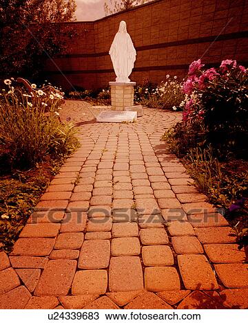 Stock Image - Mother Mary statue in garden. Fotosearch